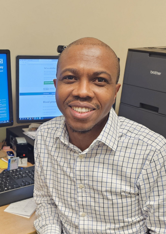 Dr.Olumide Ayodele GP Partner, Coltishall & Spixworth Surgeries at his desk