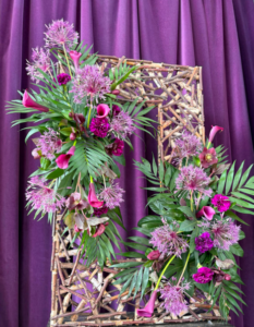 purple background then a waiker frame with two flower arrangements top and bottom, cerise pink and purple cala lillies green foilage