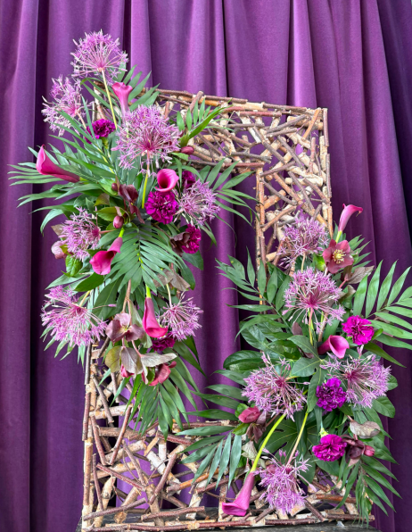 purple background then a waiker frame with two flower arrangements top and bottom, cerise pink and purple cala lillies green foilage